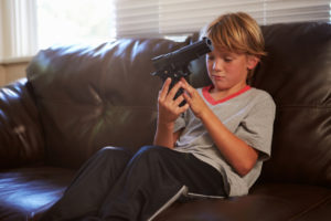 sad boy with gun illustrating an article called Gender Neutral - Change and Challenge